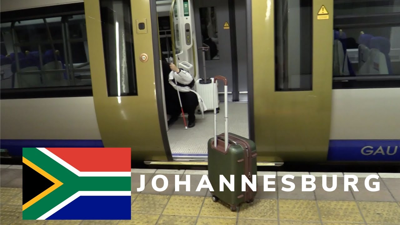 An image of Mona with her luggage and cane boarding the Johannesburg Metro.  